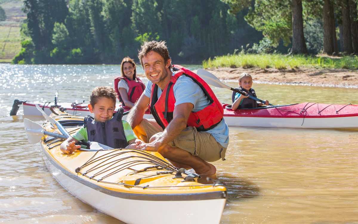 A dad and his two children are kayacking on the Yadkin River in Davie County North Carolina.